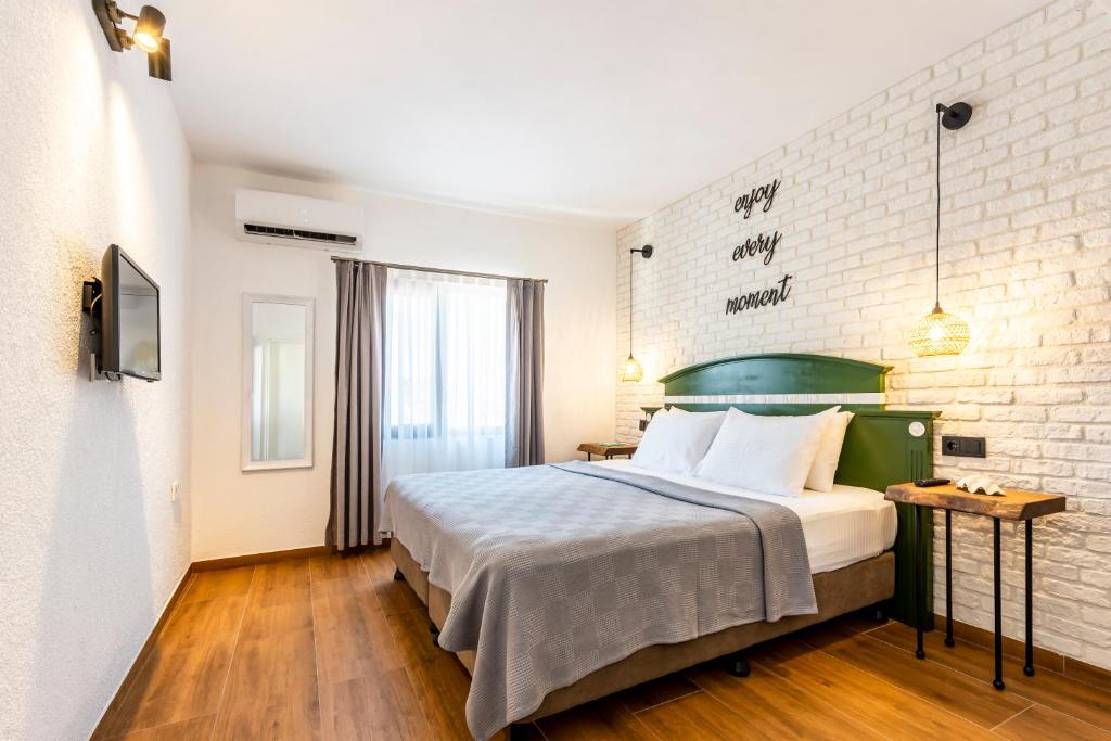 1 dormitorio con cama y pared de ladrillo en The Poyz Hotel Bodrum, en Gümbet