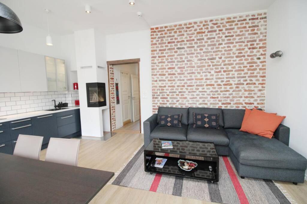 a living room with a couch and a brick wall at Nordic Host - Frogner - Well appointed 2 Bedroom in Lovely West Side Neighborhood in Oslo