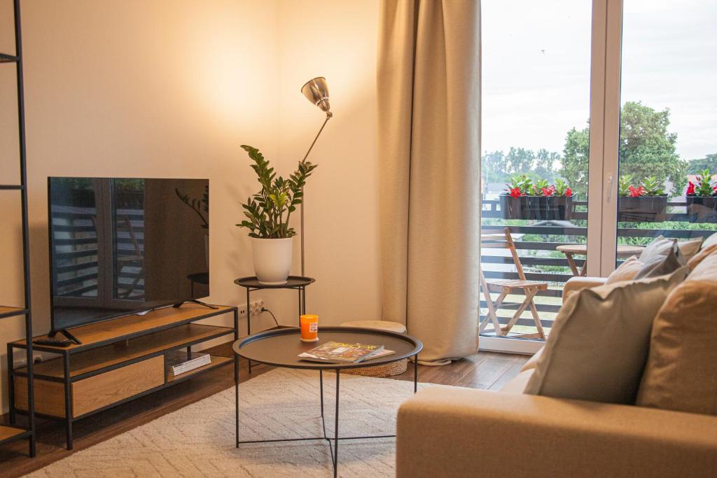uma sala de estar com um sofá e uma mesa em Przytulny Apartament Mickiewicza 14 4 em Wieleń