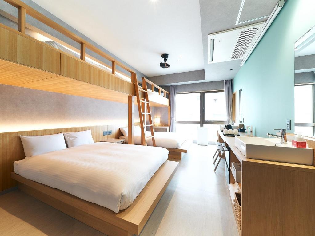 Rakuten STAY naha-tomarifuto bunk bed room في ناها: غرفة نوم مع سرير بطابقين ومكتب