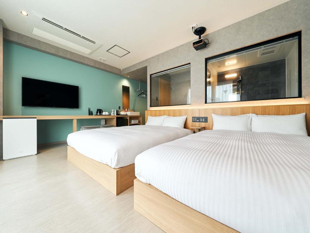 a hotel room with two beds and a tv at Rakuten STAY naha-tomarifuto 7F Twin Room in Naha