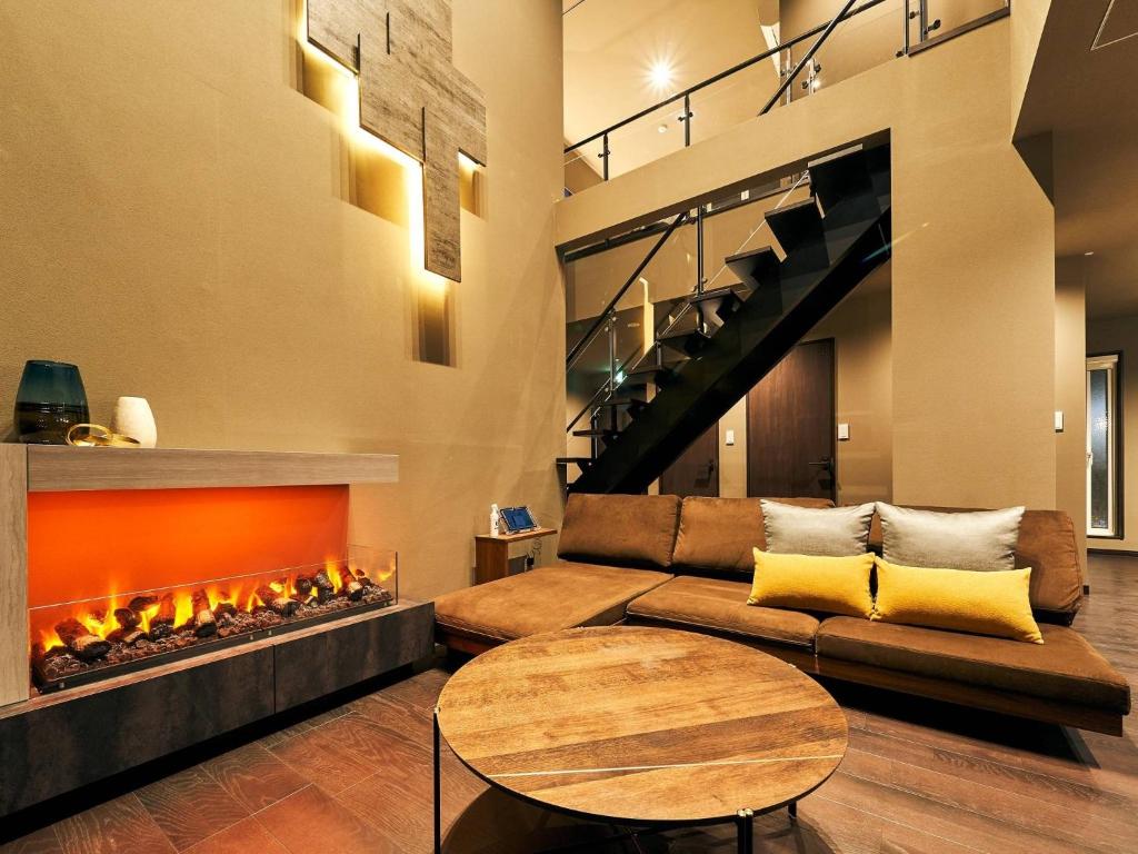 ein Wohnzimmer mit Couch und Kamin in der Unterkunft Rakuten STAY VILLA Hakone Sengokuhara North Wing 102 with Massage chair, capacity of 10 persons in Hakone