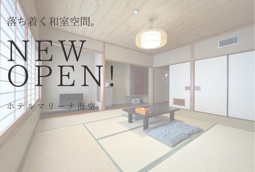 a living room with a new open sign on the wall at Marina Hotel Kaikuu in Shirahama
