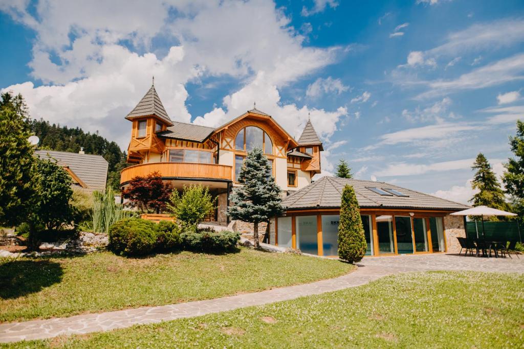 une grande maison avec un toit en gambrel dans l'établissement SKRI Villa Ružbachy, à Vyšné Ružbachy