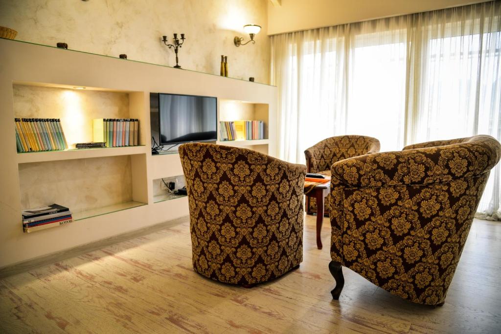 a living room with two chairs and a television at Garni Hotel TIANIS in Kotor