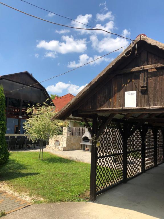 drewniany budynek z bramą w trawie w obiekcie RELAX Apartman w Nyíregyházie