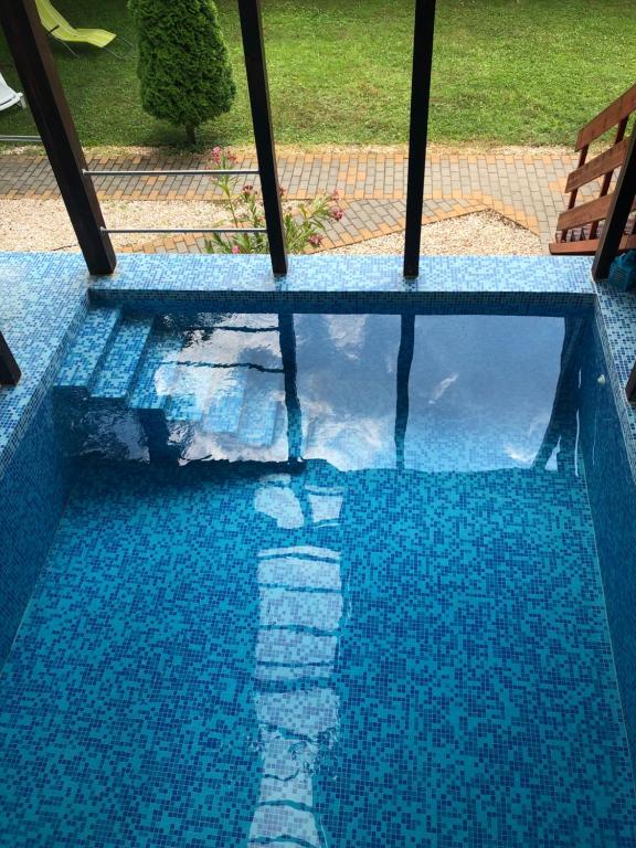 un reflejo de una persona en una piscina en RELAX Apartman, en Nyíregyháza