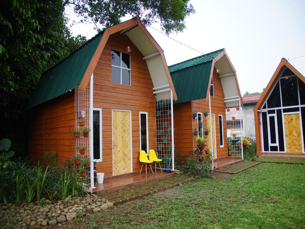 ボゴールにあるGSV Cottage Shariaの緑の屋根と黄色い椅子のある家