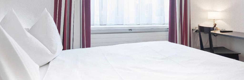 Postel nebo postele na pokoji v ubytování Hotel Hottingen