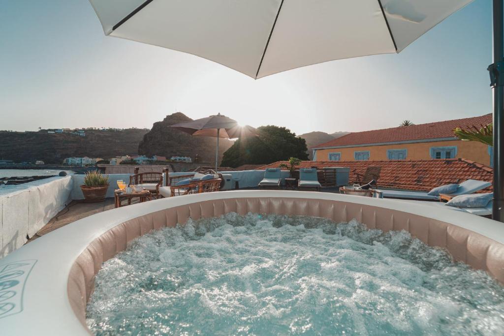 a hot tub on a patio with an umbrella at Beach Apartment in Playa de Santiago