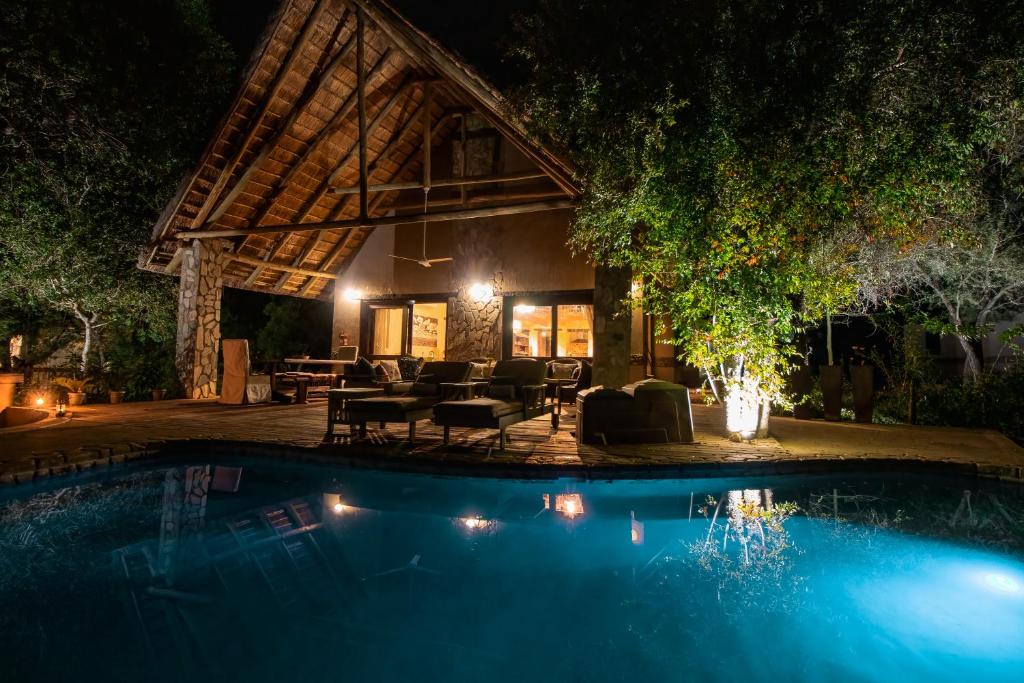 un resort con piscina di notte di Leopard's Lair Bush Lodge a Hoedspruit