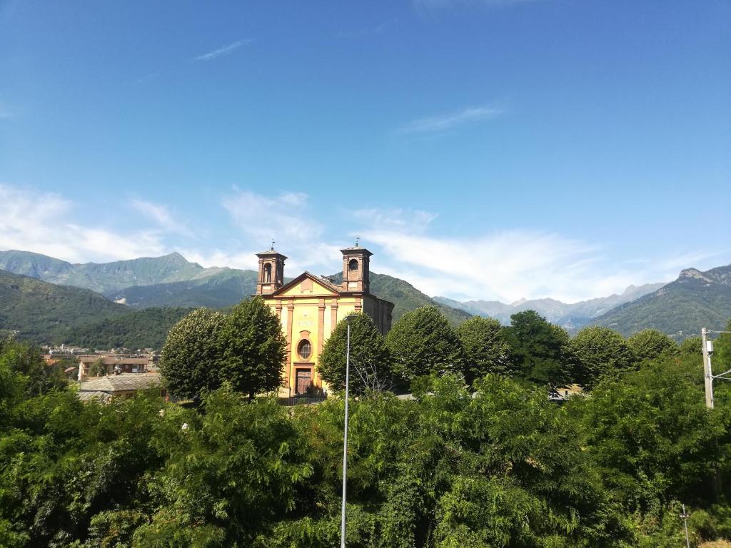 een oud huis op een heuvel met bergen op de achtergrond bij Grazioso monolocale - Borgo Malan, Luserna S. G. in Luserna San Giovanni