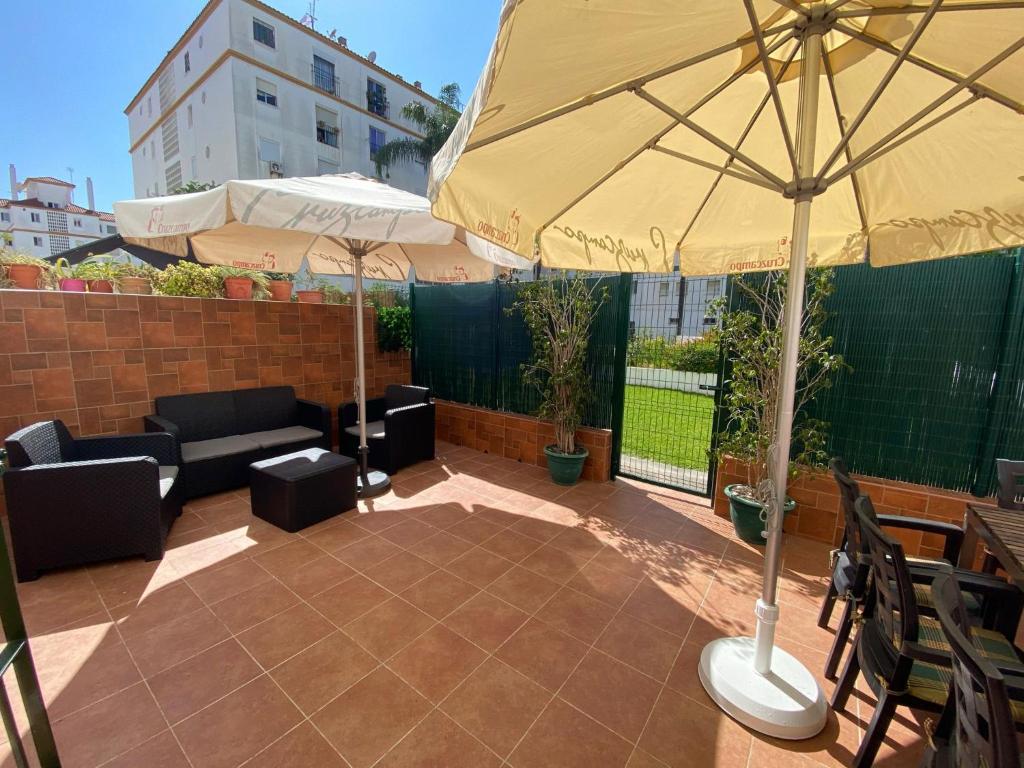eine Terrasse mit einem Sonnenschirm, einem Tisch und Stühlen in der Unterkunft Apartamento en el centro de Estepona in Estepona