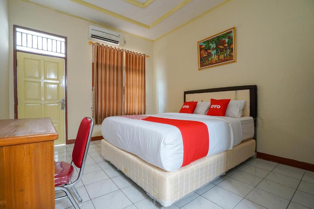 een slaapkamer met een groot bed met rode kussens bij OYO 2177 Trikora Indah Residence in Palembang