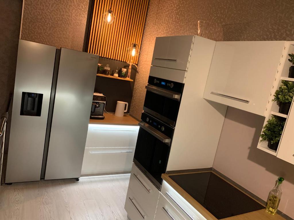 リエパーヤにあるRobezu Street Houseのキッチン(白い家電製品、白いキャビネット付)
