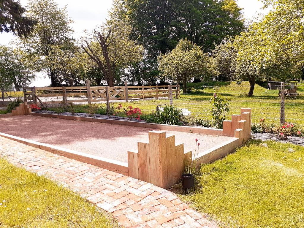 a garden with a bench in a park at les Gîtes du Château de Maltot in Saint-Ouen-du-Breuil