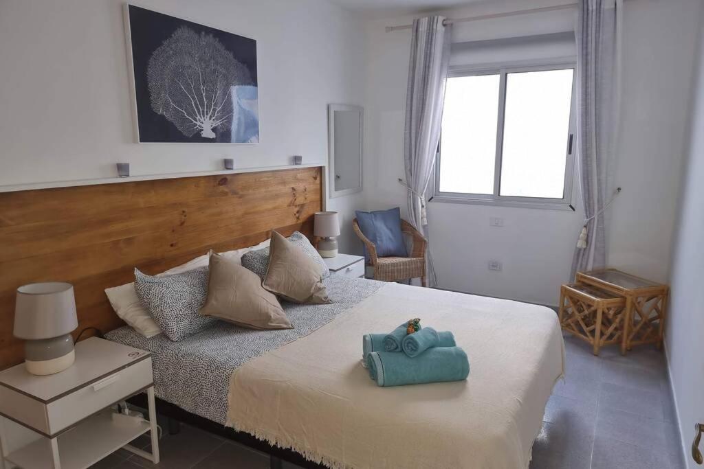 a bedroom with a bed with a blue towel on it at Casa Gales: Relax next to the Sea Apartment for Families in Corralejo