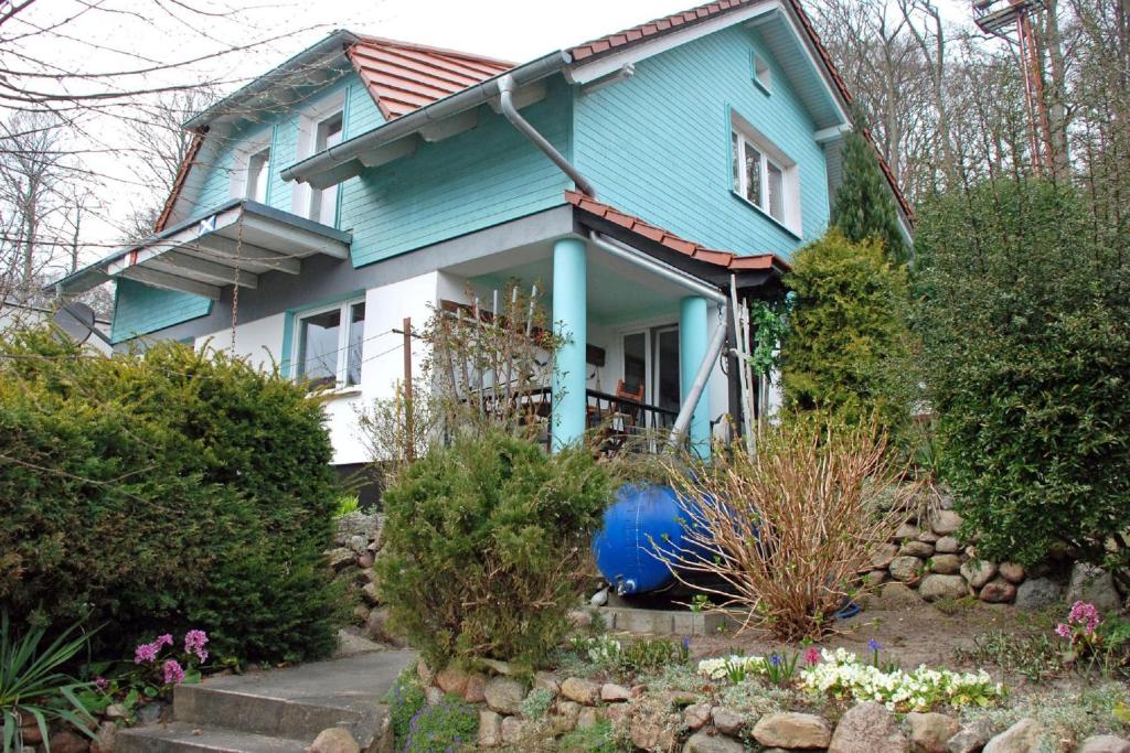 a blue house with a blue barrel in front of it at F-1042 Ferienwohnung Enna in Ostseebad Sellin