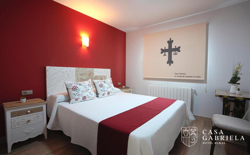 a bedroom with a bed with a red wall at Casa Gabriela Hotel in Jiménez de Jamuz