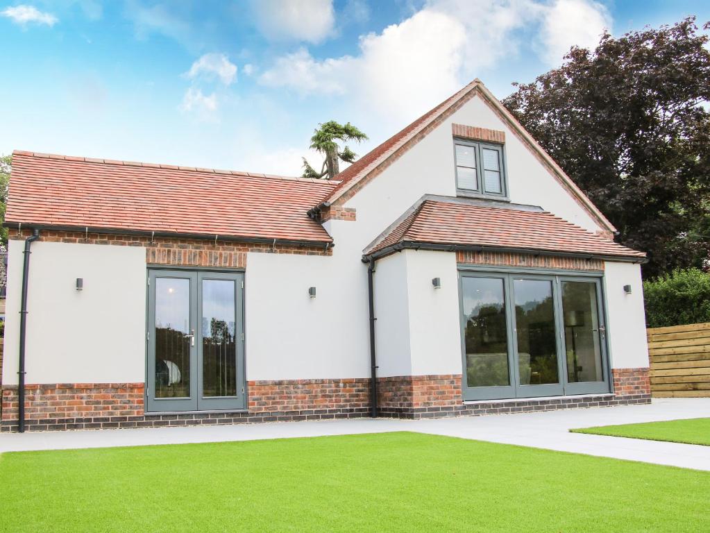 a house with large windows and a green lawn at The Wheatlands in Much Wenlock