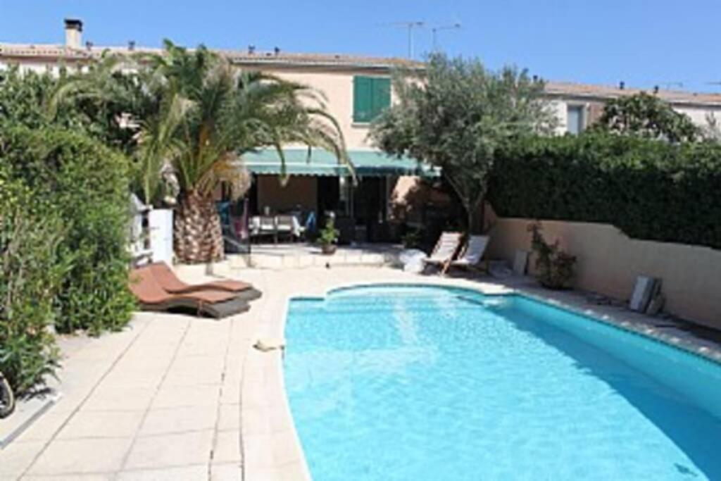 a swimming pool in a yard with palm trees at Holiday Home With Pool In Marseillan in Marseillan