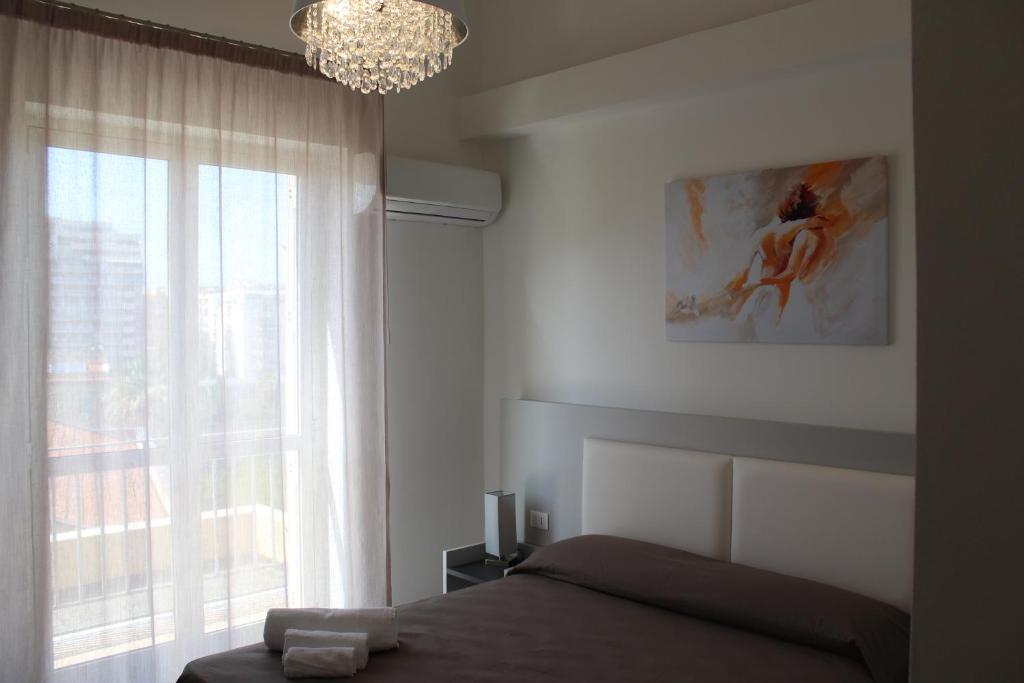 - une chambre avec un lit et une fenêtre ornée d'un lustre dans l'établissement Rahal B&B, à Palerme