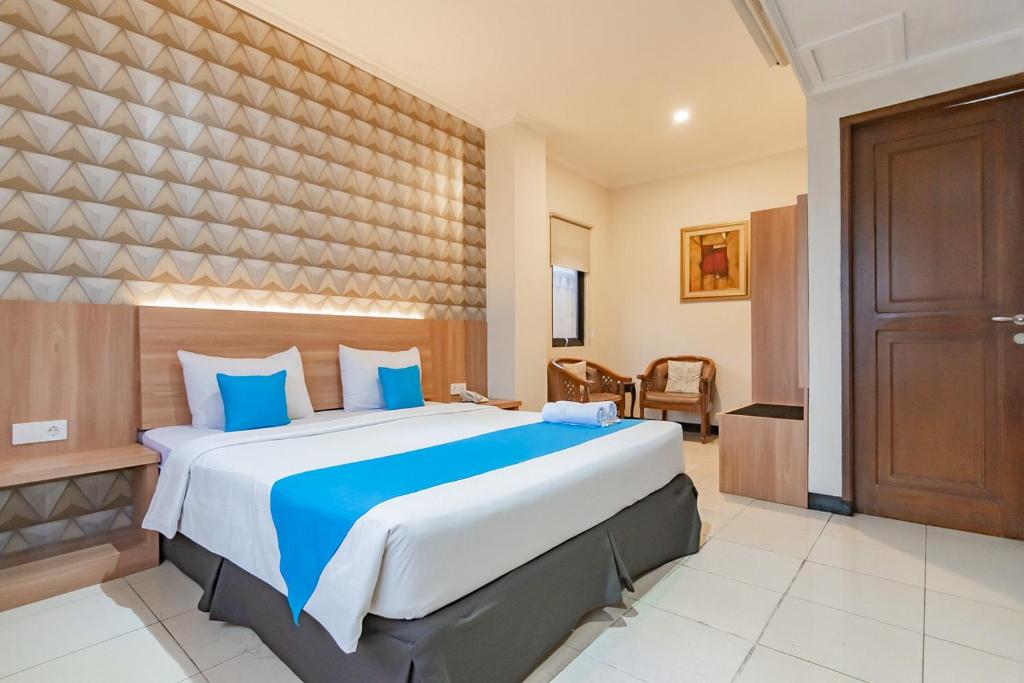 ein Schlafzimmer mit einem großen Bett mit blauen Kissen in der Unterkunft Cihampelas Hotel 2 Mitra RedDoorz in Bandung