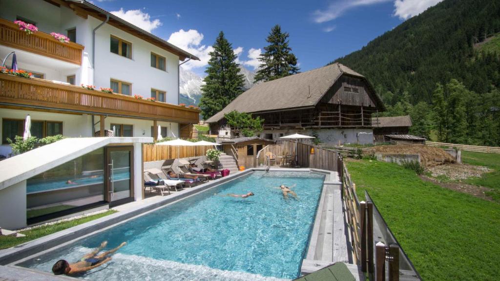 a pool with people swimming in it in a house at Appartements Pohuibe in Anterselva di Mezzo