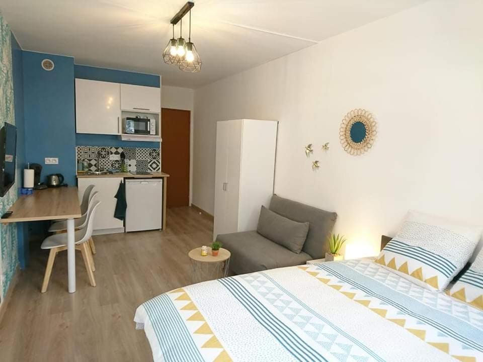 a bedroom with a bed and a kitchen with a couch at LPA in Annecy