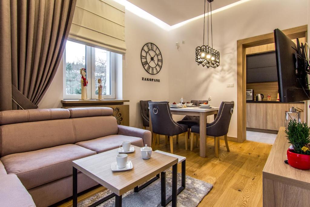 uma sala de estar com um sofá e uma mesa em ApartHost Jagiellońska Residence em Zakopane