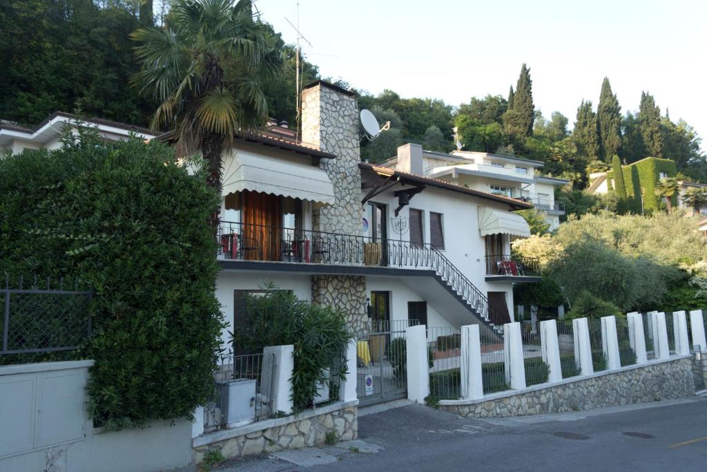 een wit huis met een hek ervoor bij Villa de Ros in Salò