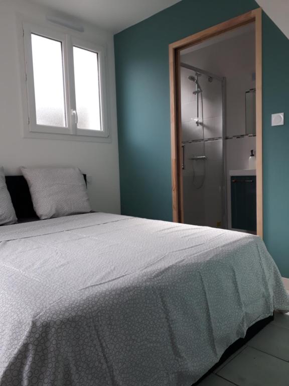 - une chambre avec un lit blanc et une salle de bains dans l'établissement Maisonette 200m de la plage, à Saint-Jean-de-Monts