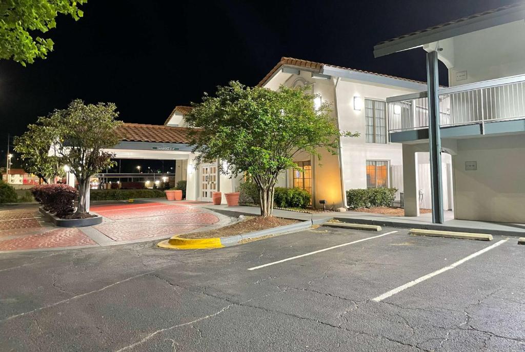 an empty parking lot in front of a building at night at Travelodge by Wyndham Tuscaloosa in Tuscaloosa