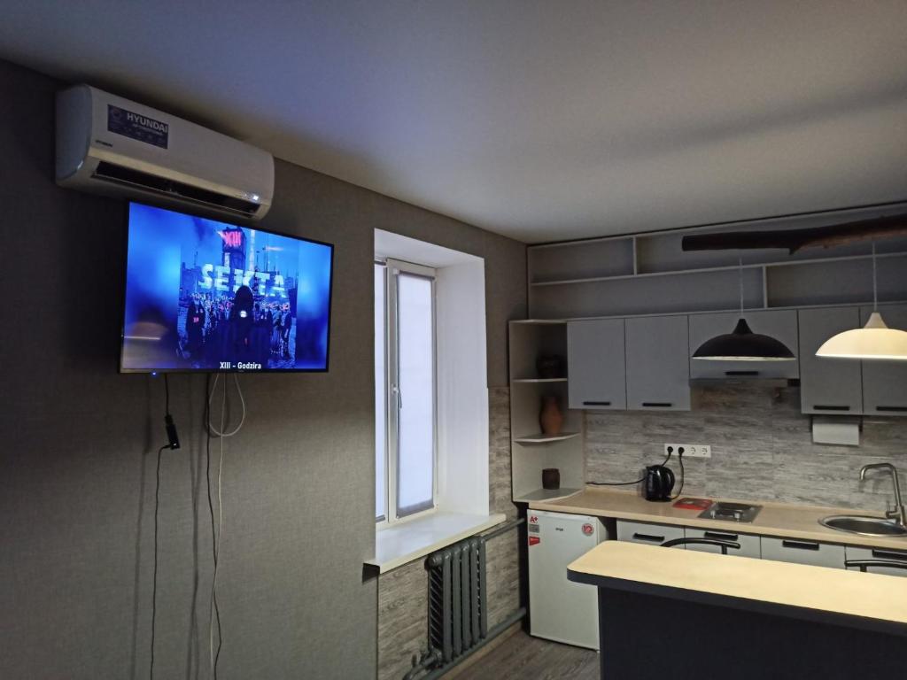 a kitchen with a flat screen tv on the wall at Квартира - студія in Konotop