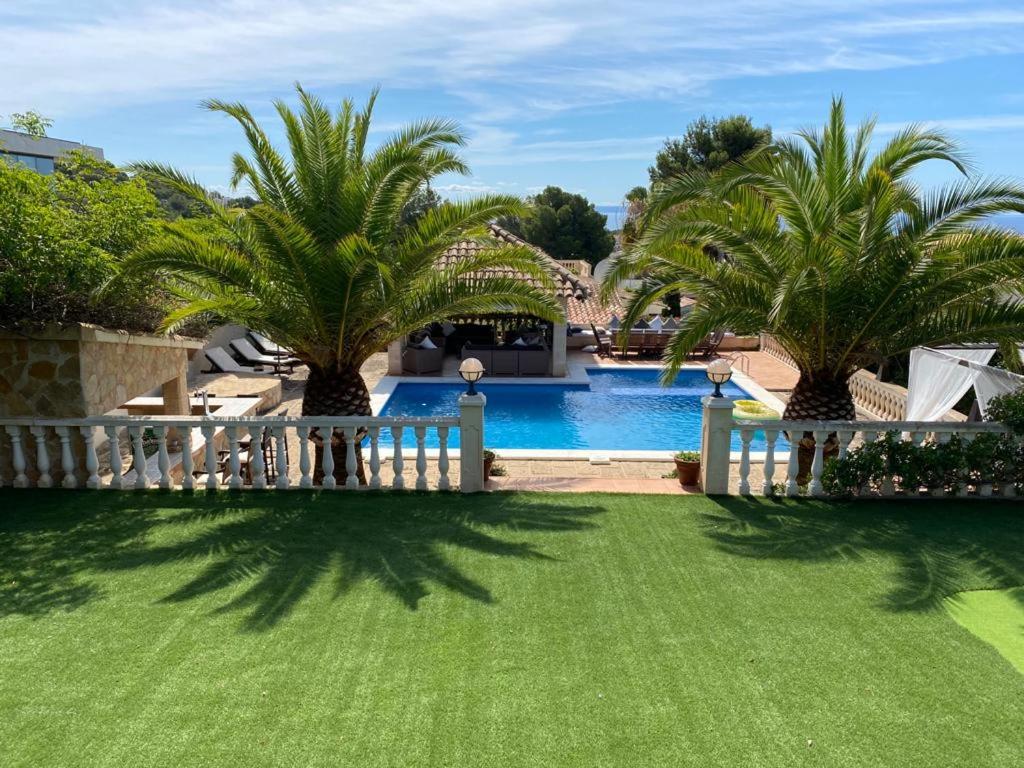 a yard with palm trees and a swimming pool at Villa Santa Lavinia in Palma de Mallorca