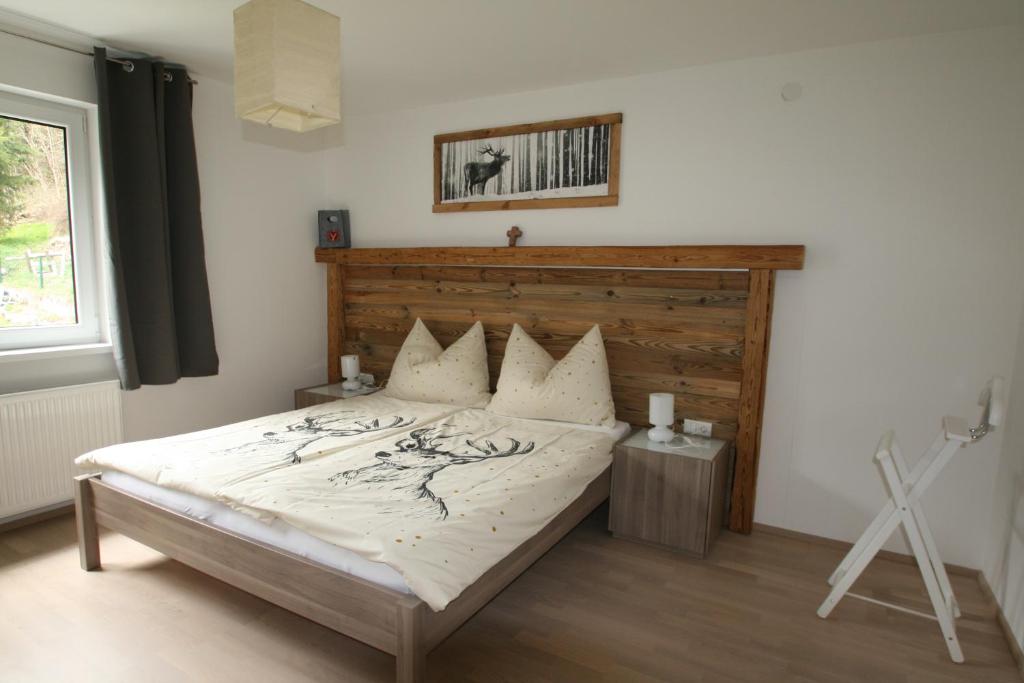 a bedroom with a bed with a wooden headboard at Apartment Daum - Deine Ferienwohnung in Mühlbach am Hochkönig in Mühlbach am Hochkönig