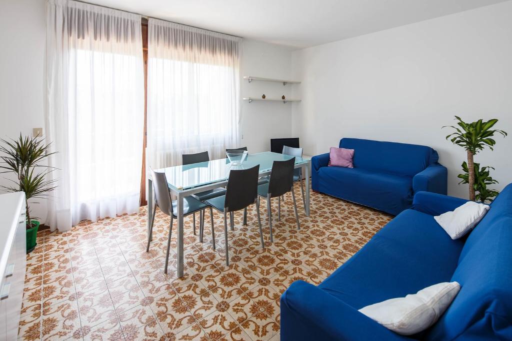 a living room with a blue couch and a table at Appartamento Calmo 3SX in Venice-Lido