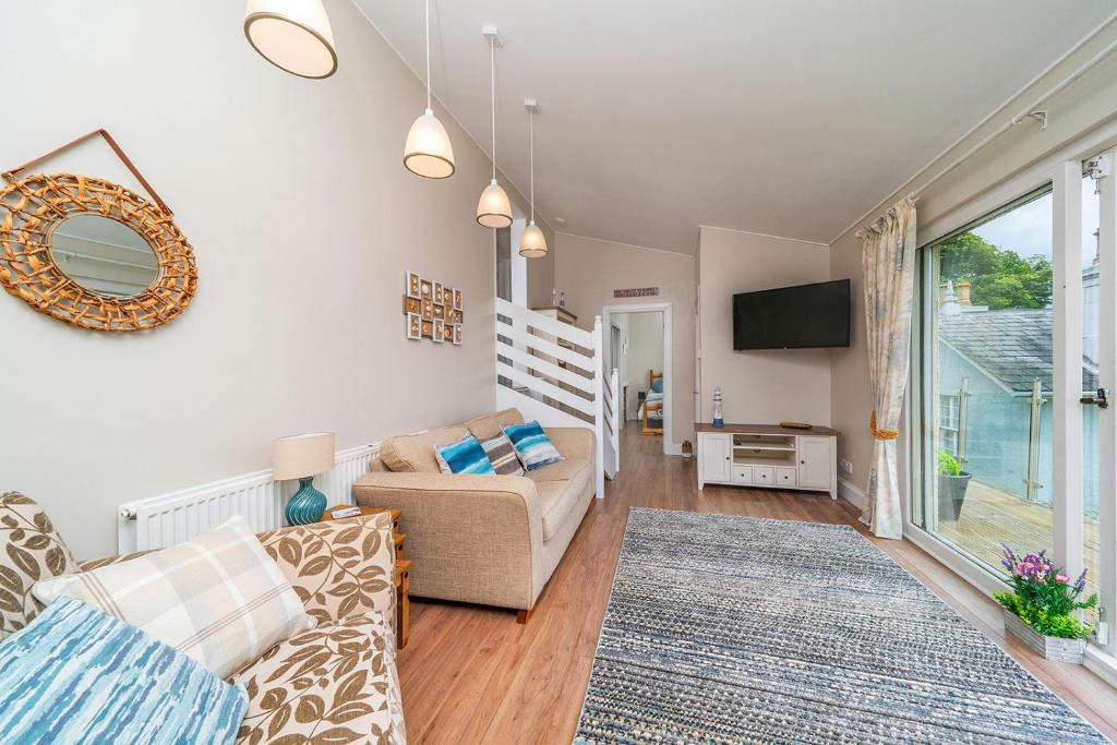 a living room with a couch and a tv at FerryView in Broughty Ferry