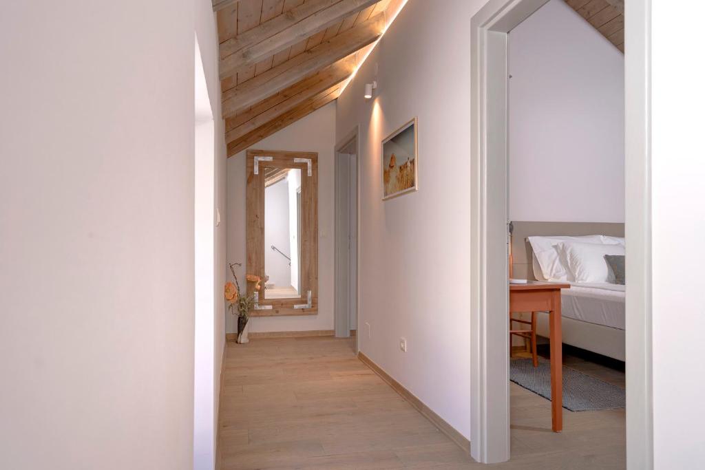 a hallway leading to a bedroom with a bed and a table at Villa Zanino in Veliko Grablje