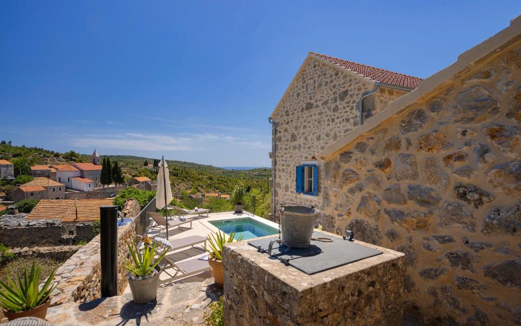 a stone building with a swimming pool and a house at Villa Zanino in Veliko Grablje