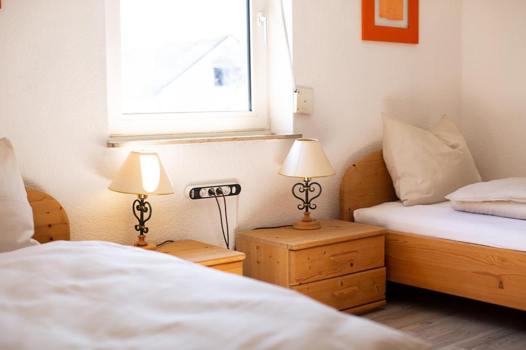 two beds in a room with two lamps and a window at Haus Pia - Monteur Haus in Bubesheim