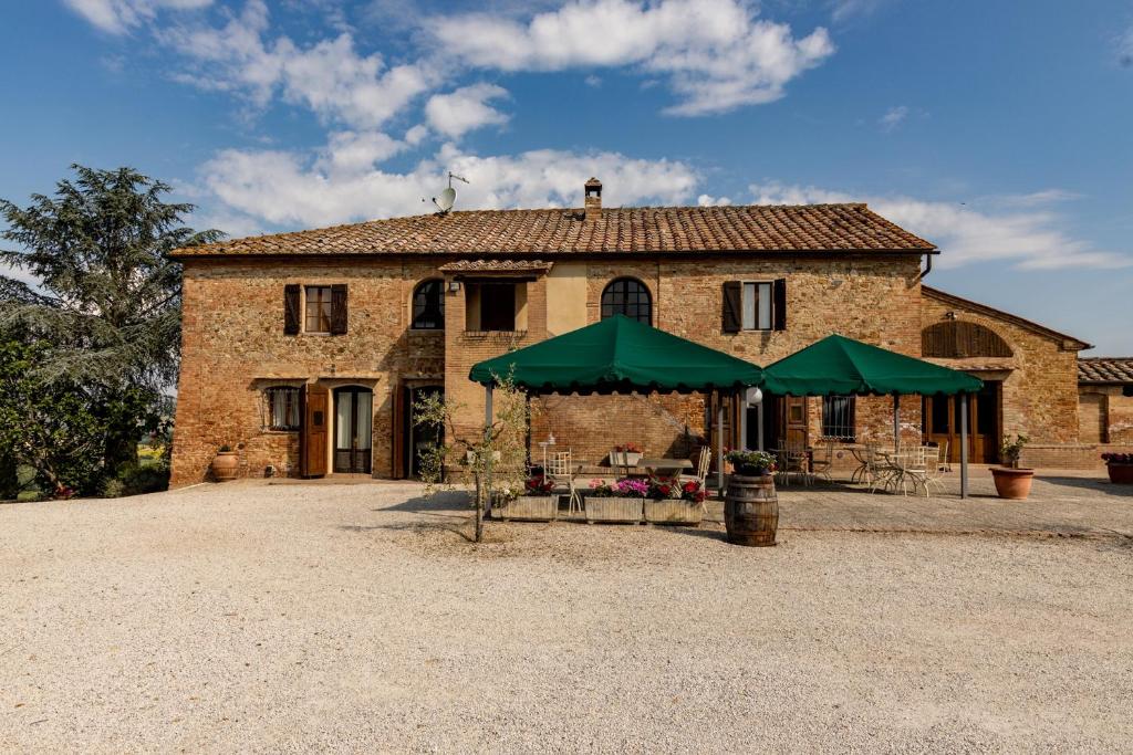 a building with a green umbrella in front of it at Agriturismo Percenna in Buonconvento