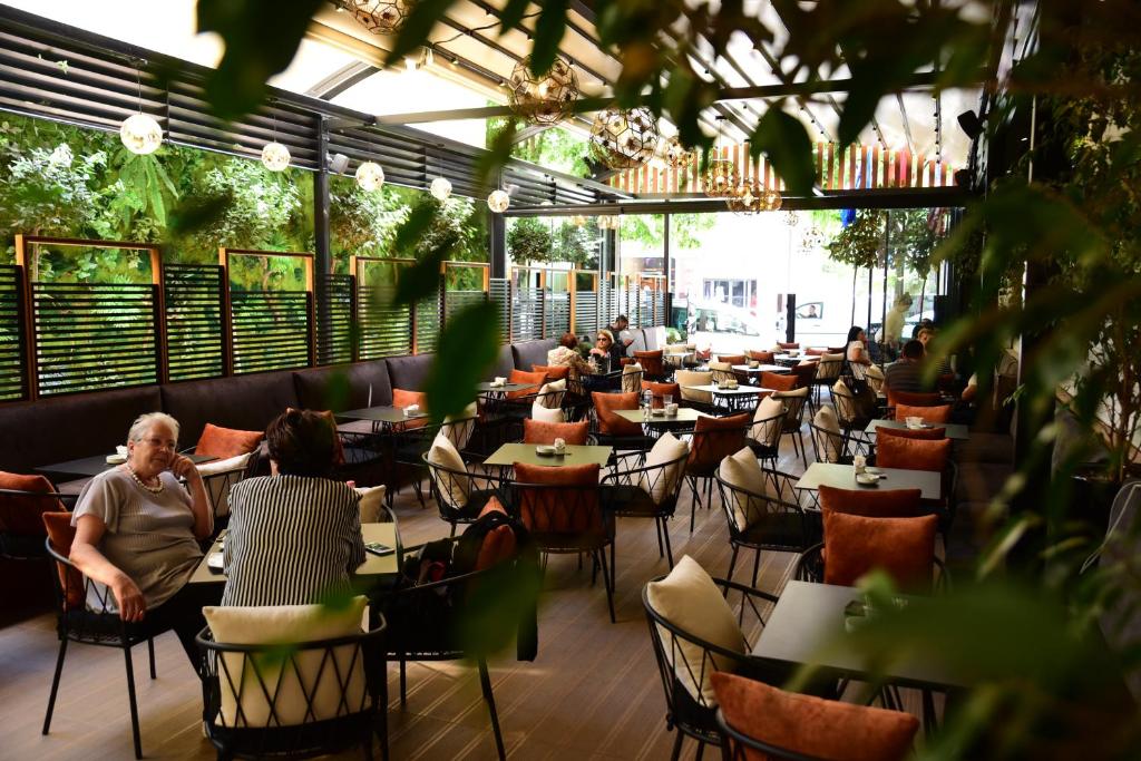 des gens assis à des tables dans un restaurant vide dans l'établissement Hotel Comfort, à Tirana