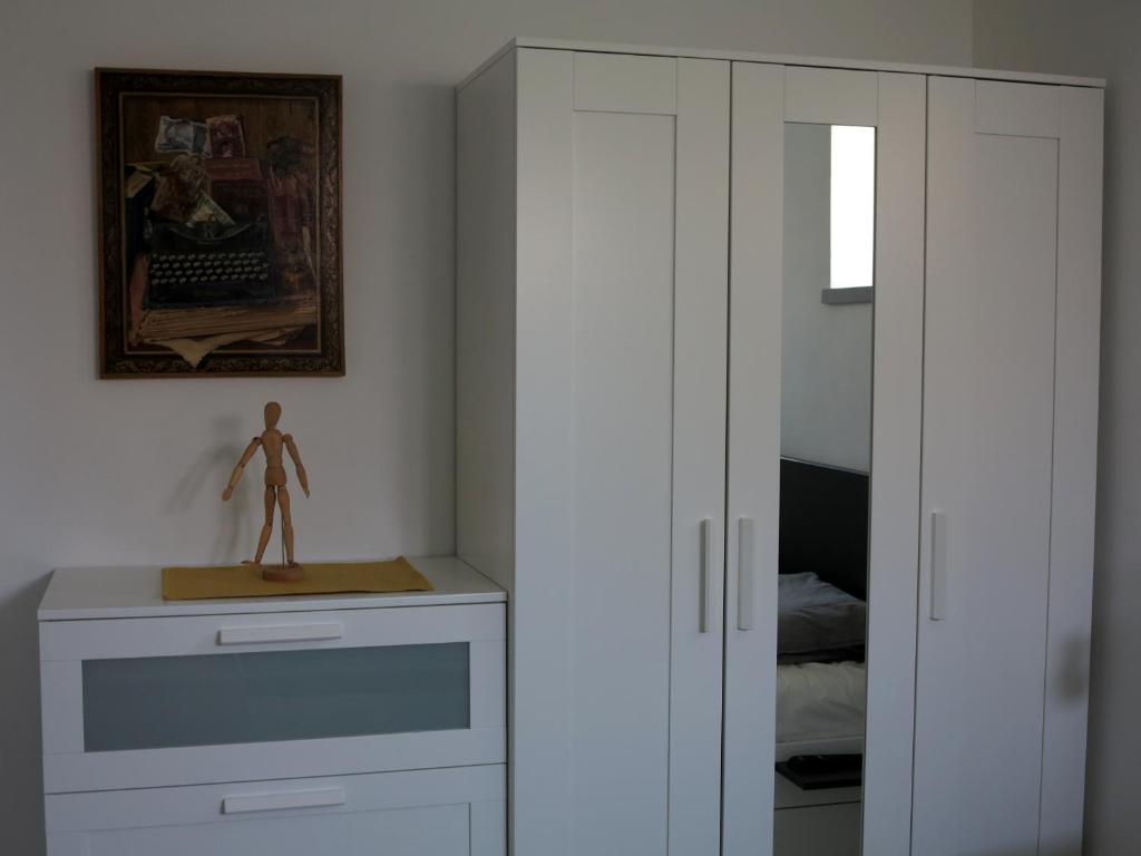 sypialnia z białymi szafkami i manekinem na ladzie w obiekcie művészház apARTman w Balatonfüred