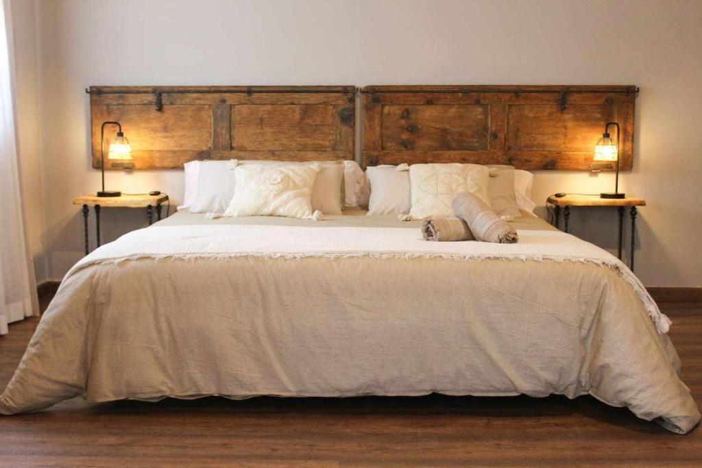 a bedroom with a large bed with two end tables at Casa El Tío Carrascón alojamiento rural in Cerveruela