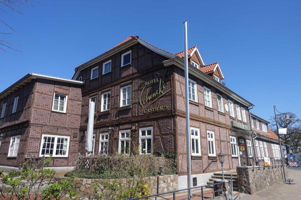 un bâtiment en brique brune avec un panneau sur celui-ci dans l'établissement Landhaus Amelinghausen Ferienwohnung, à Amelinghausen