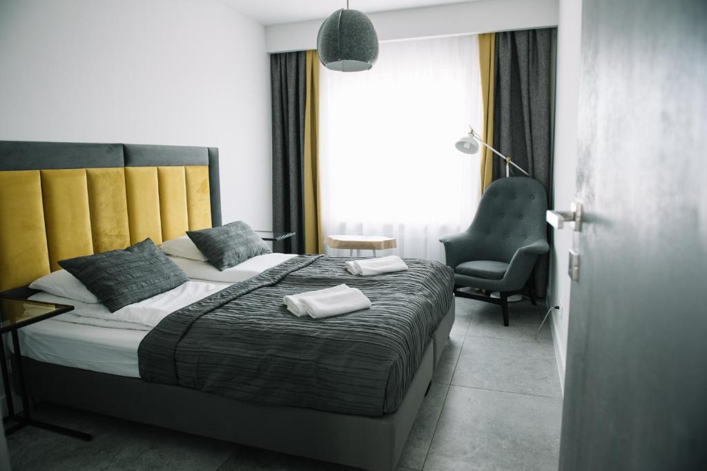 um quarto com uma cama com duas toalhas em APARTAMENT BUŁGARSKA 60m2-3 POKOJE-PIĘKNY WIDOK-13 PIĘTRO 24H CHECK IN em Poznań