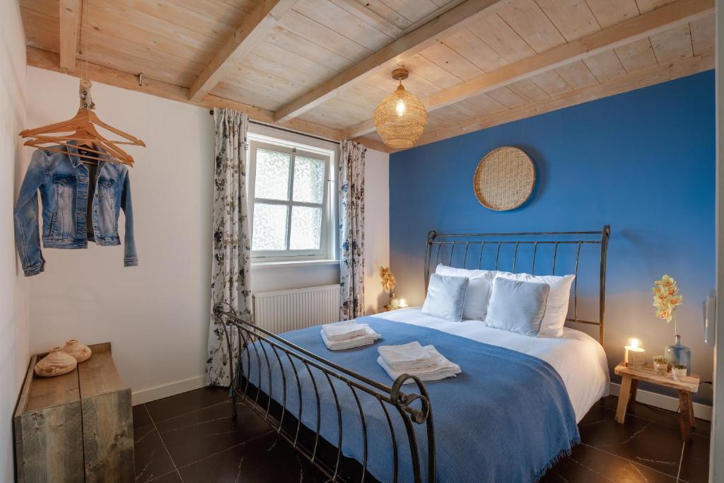 a blue bedroom with a large bed with blue walls at De Slaaperij in Wilbertoord