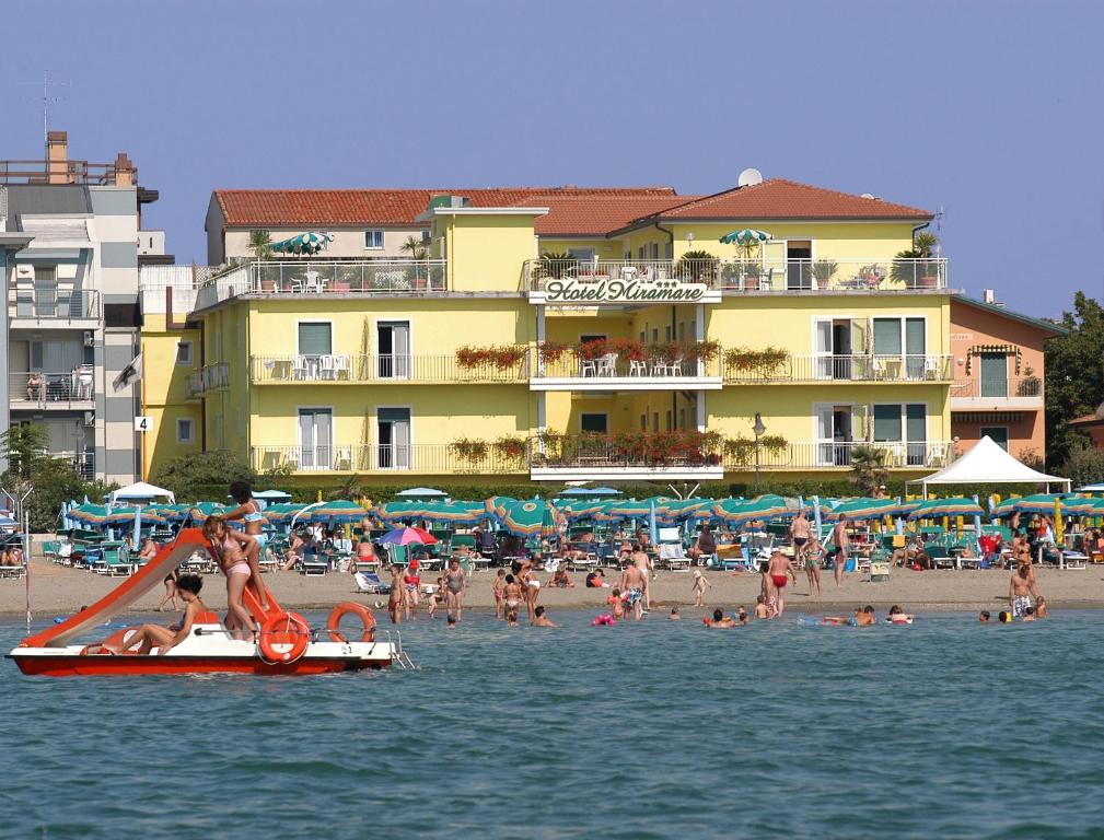 a group of people on a beach with buildings at Hotel Miramare in Caorle