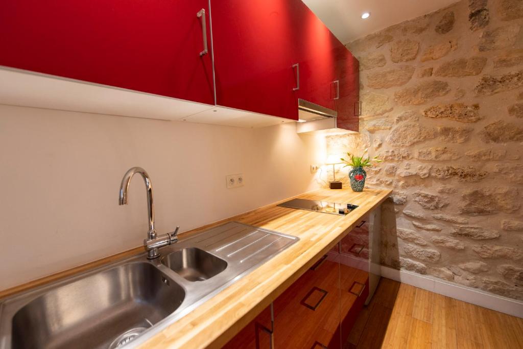巴黎的住宿－Popy，一个带水槽和红色橱柜的厨房